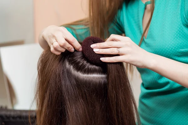 Coiffeur faire coiffure du soir sur cheveux bruns dans le salon de beauté — Photo