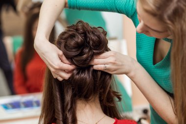 Profesyonel kuaför şekillendirme uzun kadın kıvırcık saçlı. Emotiona