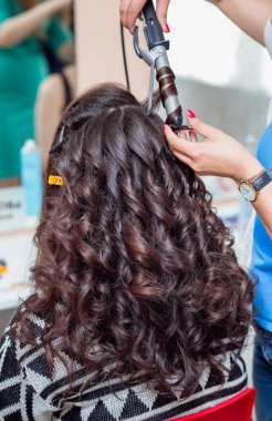 Perma aleti kullanarak saç bukleler, yakın çekim, çekim, bar için stilist