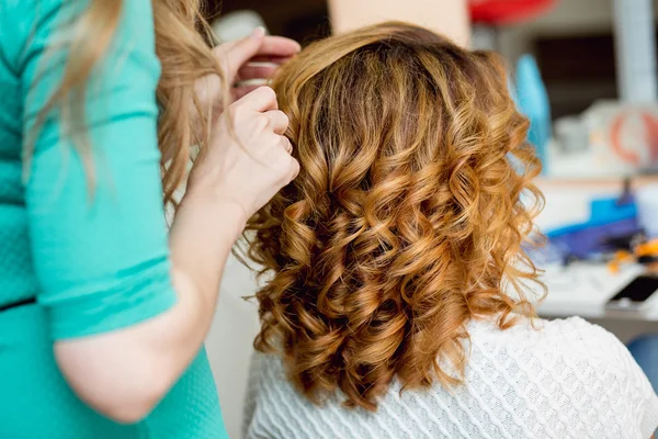 Stylist using curling iron for hair curls, close-up, shot in barber beauty salon — Stock Photo, Image