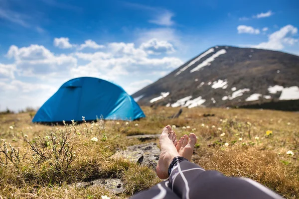 Meztelen láb és a lábak, a háttérben a camping idegenforgalmi természetjáró — Stock Fotó