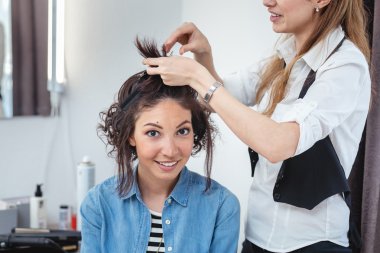 Saç stilisti elebaşı mutlu bir esmer kadın yapma. Hairdres