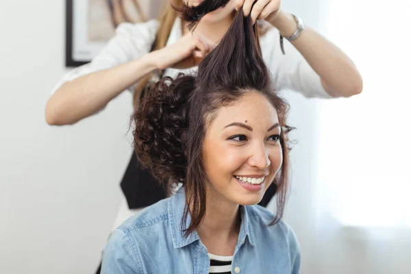 Jovem menina alegre fazendo penteado em uma barbearia. A menina sm — Fotografia de Stock