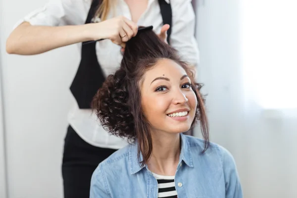 Young cheerful girl doing hairstyle in a barbershop. The girl sm — Stock Photo, Image