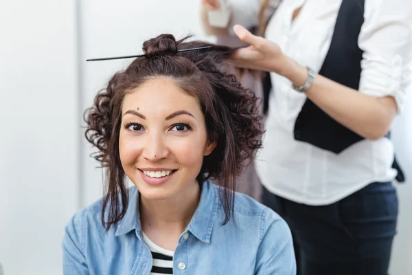 Young cheerful girl doing hairstyle in a barbershop. The girl sm — Stock Photo, Image