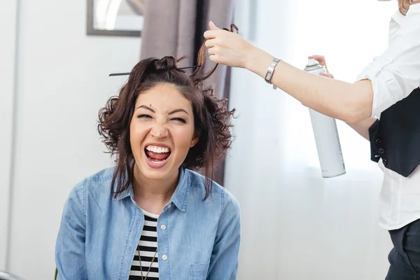 Женщина парикмахер стоя и делая прическу, чтобы мило мило — стоковое фото