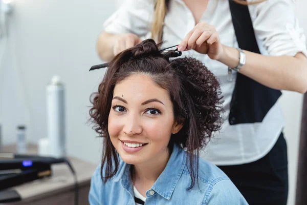 Молода весела дівчина робить зачіску в перукарні. Дівчина посміхається — стокове фото