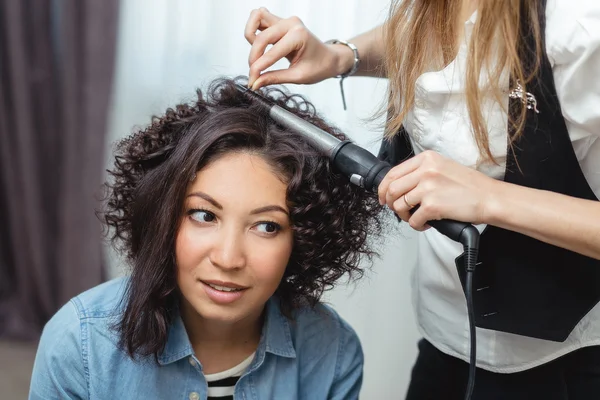 Beautiful woman having her hair curled in barber salon — Stock Photo, Image