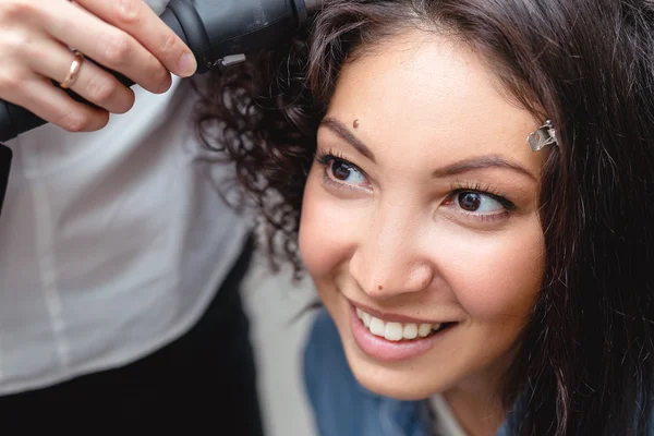 A professional hairdresser makes modern fine hairdo with the cur — Stock Photo, Image