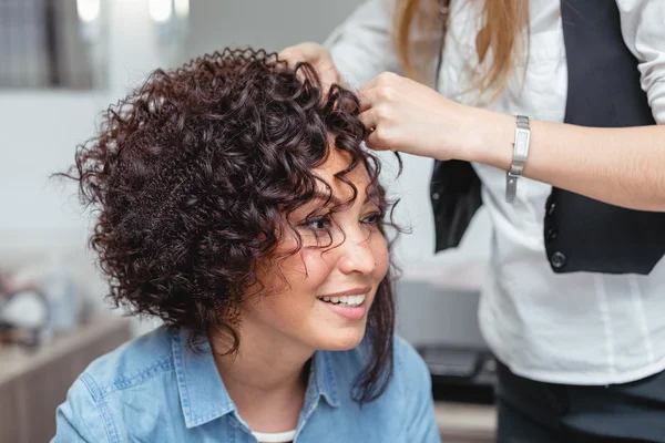 A professional hairdresser makes modern fine hairdo with the cur — Stock Photo, Image