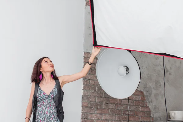 Fotógrafo mulher com câmera funciona em um estúdio profissional wi — Fotografia de Stock