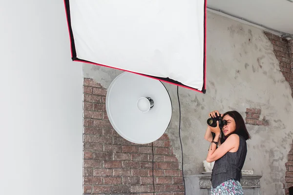 Fotógrafa con cámara trabaja en un estudio profesional wi — Foto de Stock