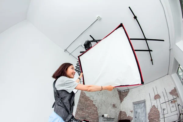 Женщина-фотограф с широким спектром студийного освещения — стоковое фото