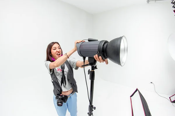 Fotógrafa mujer ajusta el equipo flash, cámara y softbox i — Foto de Stock