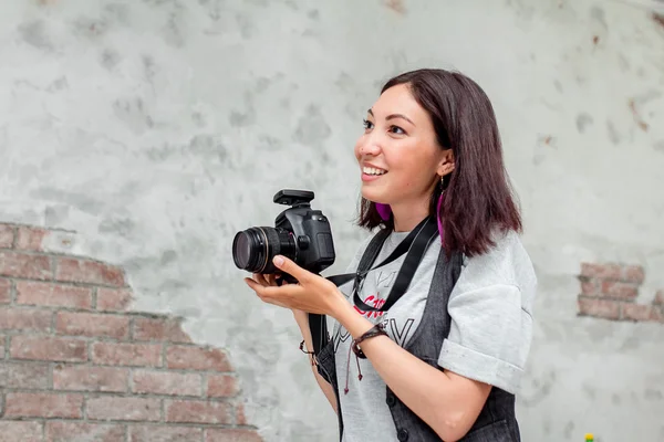 Mujer fotógrafa tomando fotos con cámara dslr en el interior con g — Foto de Stock