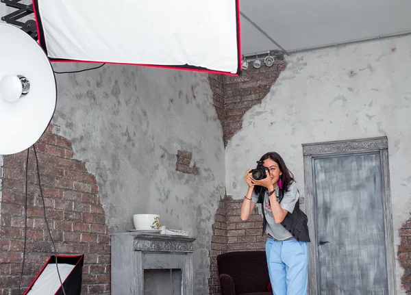 Fotógrafa mujer ajusta el equipo flash, cámara y softbox i — Foto de Stock