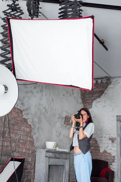 Фотограф-жінка налаштовує обладнання спалаху, фотоапарату та софтбоксу i — стокове фото