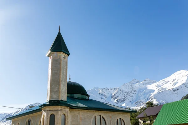 Minarete de mezquita al atardecer, con montañas sobre fondo —  Fotos de Stock