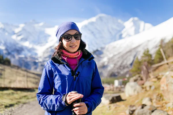 Woman hiker walking in Himalaya Mountains in Nepal. Trekking on snow white winter nature, beautiful mountain landscape.