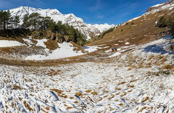 Sunny landscape in Caucasus mountains in spring with snow and grass, Elbrus region