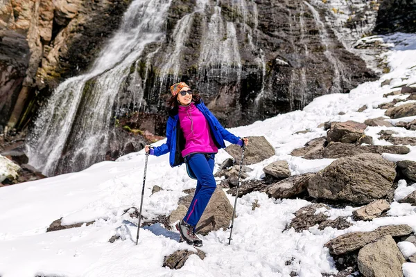 Menina caminhante desfrutando cachoeira montanha com neve no início da primavera — Fotografia de Stock