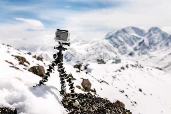 Action camera mounted on a tripod gorilla with snow-capped mountains in the background — Stock Photo, Image