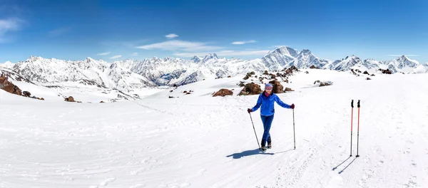 Wanderin an einem sonnigen Wintertag in der Berglandschaft. Wanderin in warmer, heller Kleidung genießt Wanderung auf schneebedeckter Piste. — Stockfoto