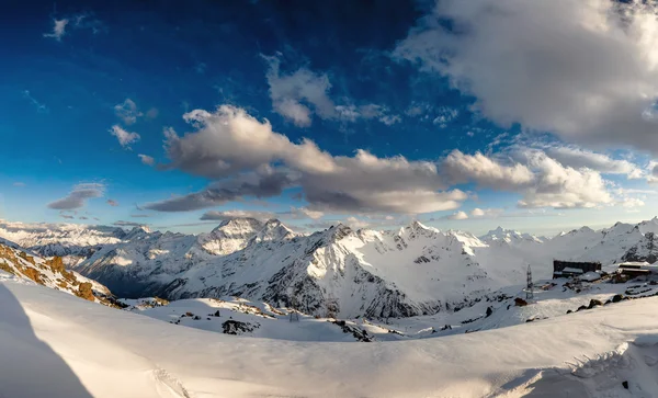 Panorama de altas montañas picos al atardecer. Paisaje en las colinas de nieve — Foto de Stock