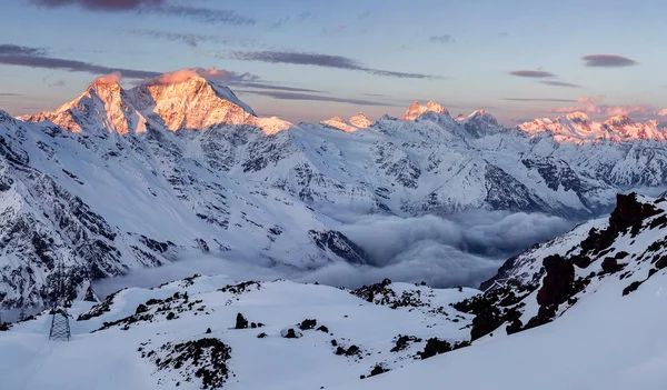 Paesaggio invernale nebbioso con un'alba colorata in montagna con nuvole di nebbia — Foto Stock
