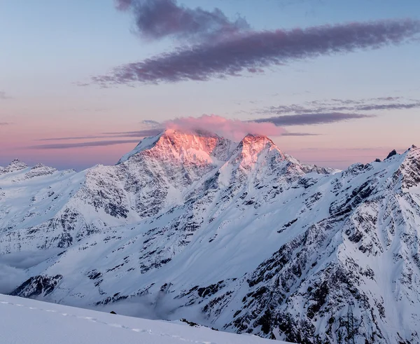 Montagne innevate invernali al tramonto. Effetto tonificante creativo. Bellissimo paesaggio invernale nelle montagne del Caucaso — Foto Stock