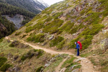 Kadın dağ uzun yürüyüşe çıkan kimse sırt çantası ile zevk görünümünde Kafkas Dağları, Elbrus region, Rusya Federasyonu.