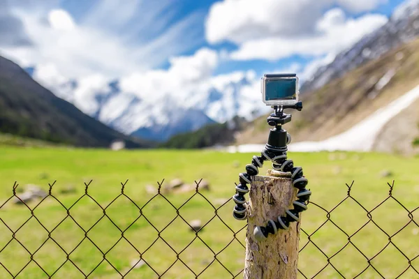 Kamera aksi dipasang pada gorila tripod dengan pegunungan bersalju di latar belakang — Stok Foto