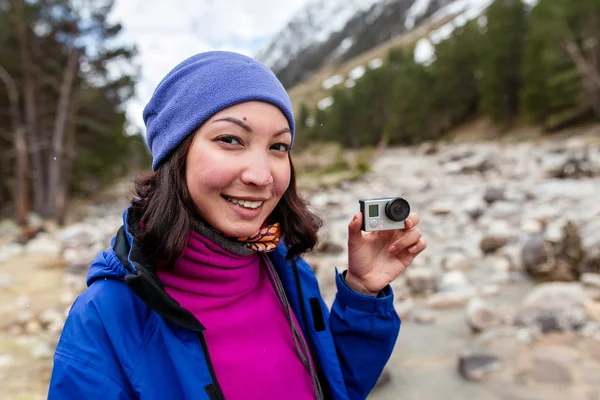 Frau mit Action-Kamera beim Wandern im Herbstwald in den Bergen. Erholung und gesunder Lebensstil im Freien in der Natur. — Stockfoto