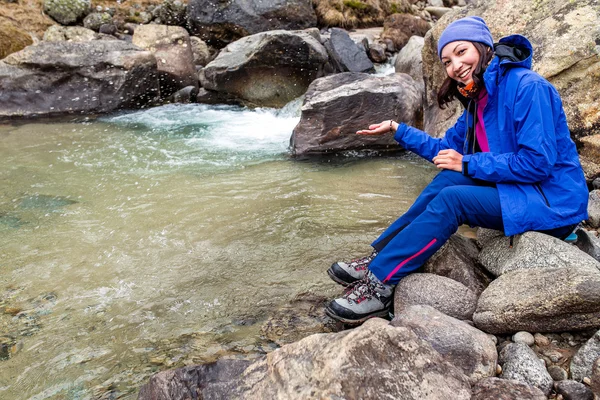 Hiker kobieta bierze wodę z rzeki w szwajcarskich górach na przygodę wędrówki. — Zdjęcie stockowe