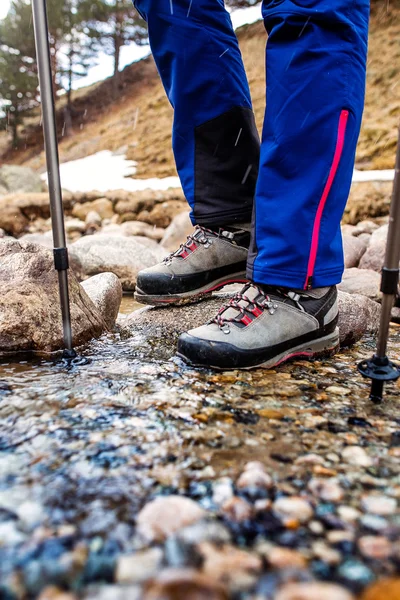 Waterdichte trekking laarzen waden een rotsachtige bergbeek. Het concept van hoge kwaliteit hiking uitrusting — Stockfoto