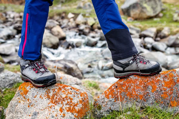 Wandelen en wandelen laarzen lopen op de oranje mos bedekte stenen. Begrip kwaliteit hiking schoenen — Stockfoto