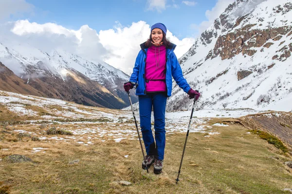 Una joven feliz mientras caminaba en las altas montañas levantó sus bastones de trekking —  Fotos de Stock