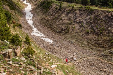 Adam backpacker arasındaki büyük kırmızı rock uçurumlar, Kuru nehir yatağı derin çöl gorge kanyon içinde Kafkas Dağları hiking