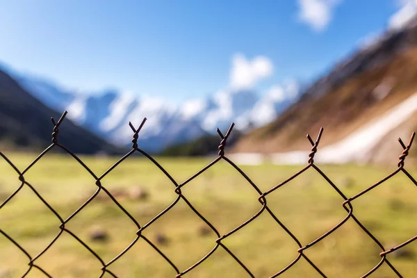 金属棒とぼやけ山の背景に有刺鉄線のフェンス。閉じた旅行地域の概念 — ストック写真