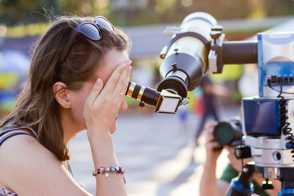 Junge Frau blickt durch Sonnenteleskop — Stockfoto