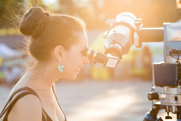 Joven mujer sonriente mirando hacia el cielo a través de telesco astronómico —  Fotos de Stock