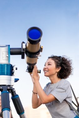 Astronomik teleskop havaya doğru seyir genç gülümseyen kadın