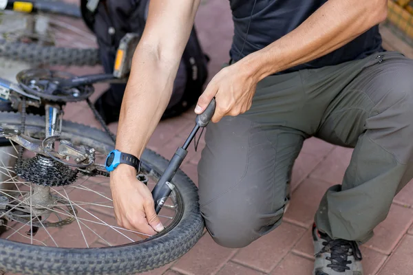 Der Mann pumpte das Rad ab — Stockfoto