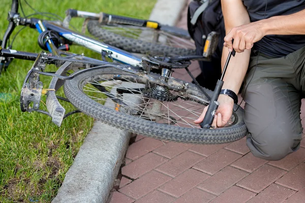 Der Mann pumpte das Rad ab — Stockfoto