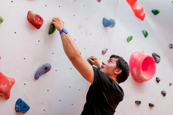 Homem alpinista na parede de escalada artificial — Fotografia de Stock