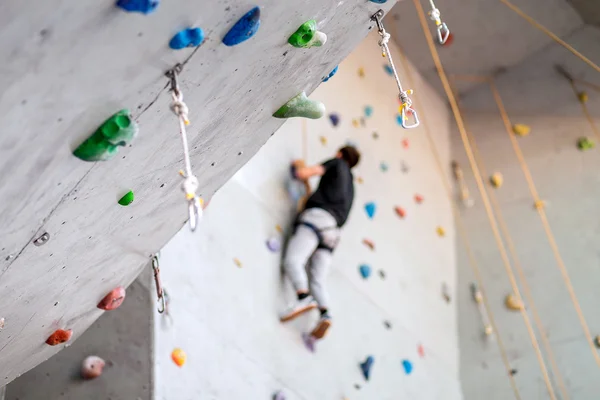 Homme grimpant sur le mur pratique intérieur, sécurisant les mousquetons et la corde — Photo