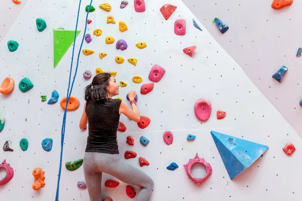 Athletic woman climbing indoors, view from the back — Stock Photo, Image