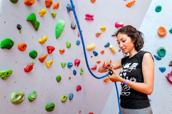 美しい女性ロック ・ クライマー ロープで別の登山者をビレイの肖像画。室内で人工壁を登ると機器. — ストック写真