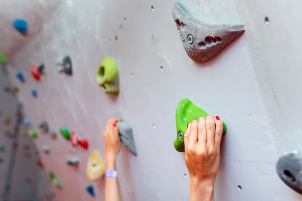 Manos de escalador sosteniendo roca artificial en el gimnasio de escalada, primer plano — Foto de Stock