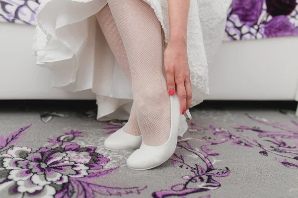 Gelin beyaz düğün ayakkabıları gösterir — Stok fotoğraf